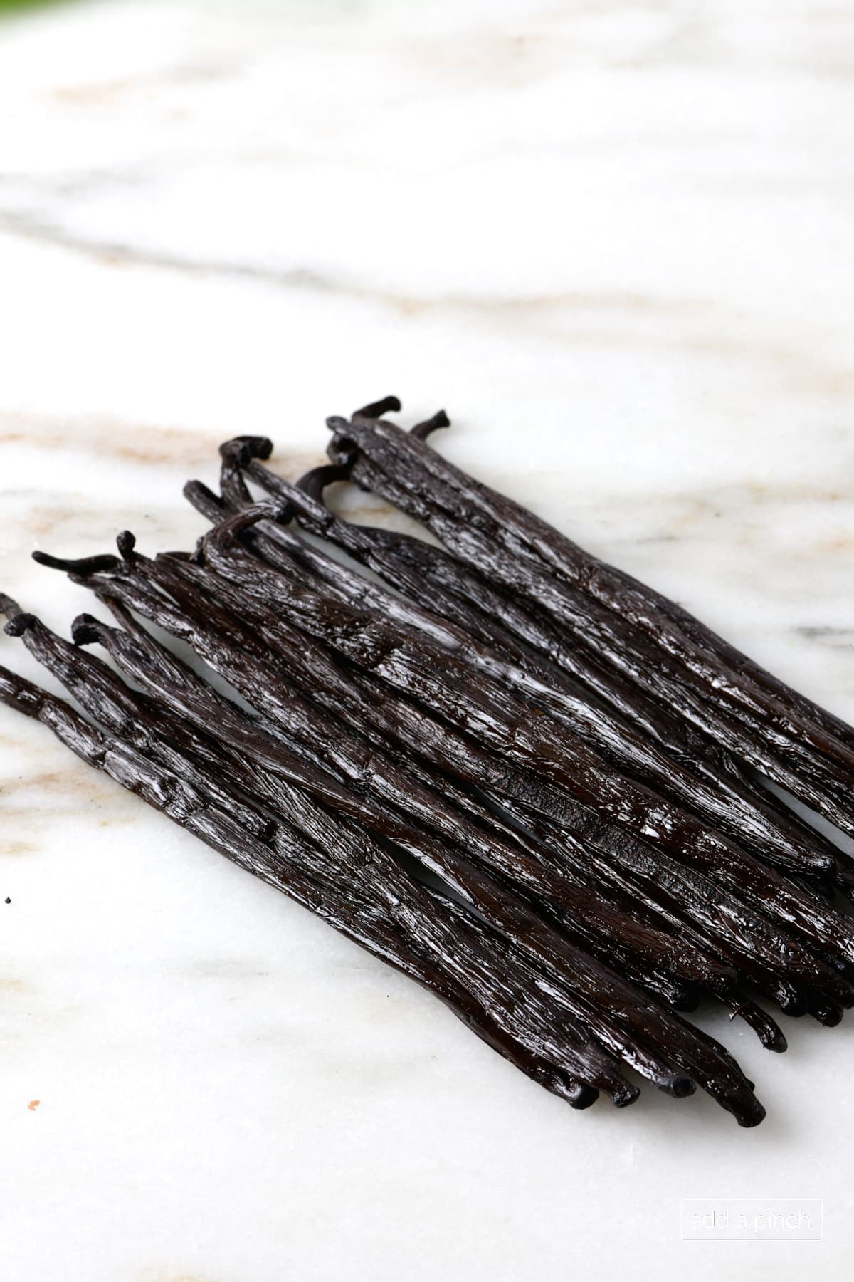 Vanilla beans on a marble countertop.